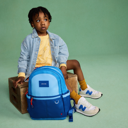 Boy sitting with state bags kane mini bakpack blue colorblock