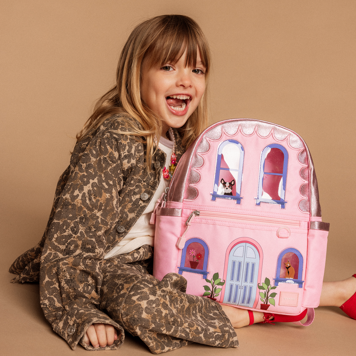 Girl sitting with STATE Bags Kane House