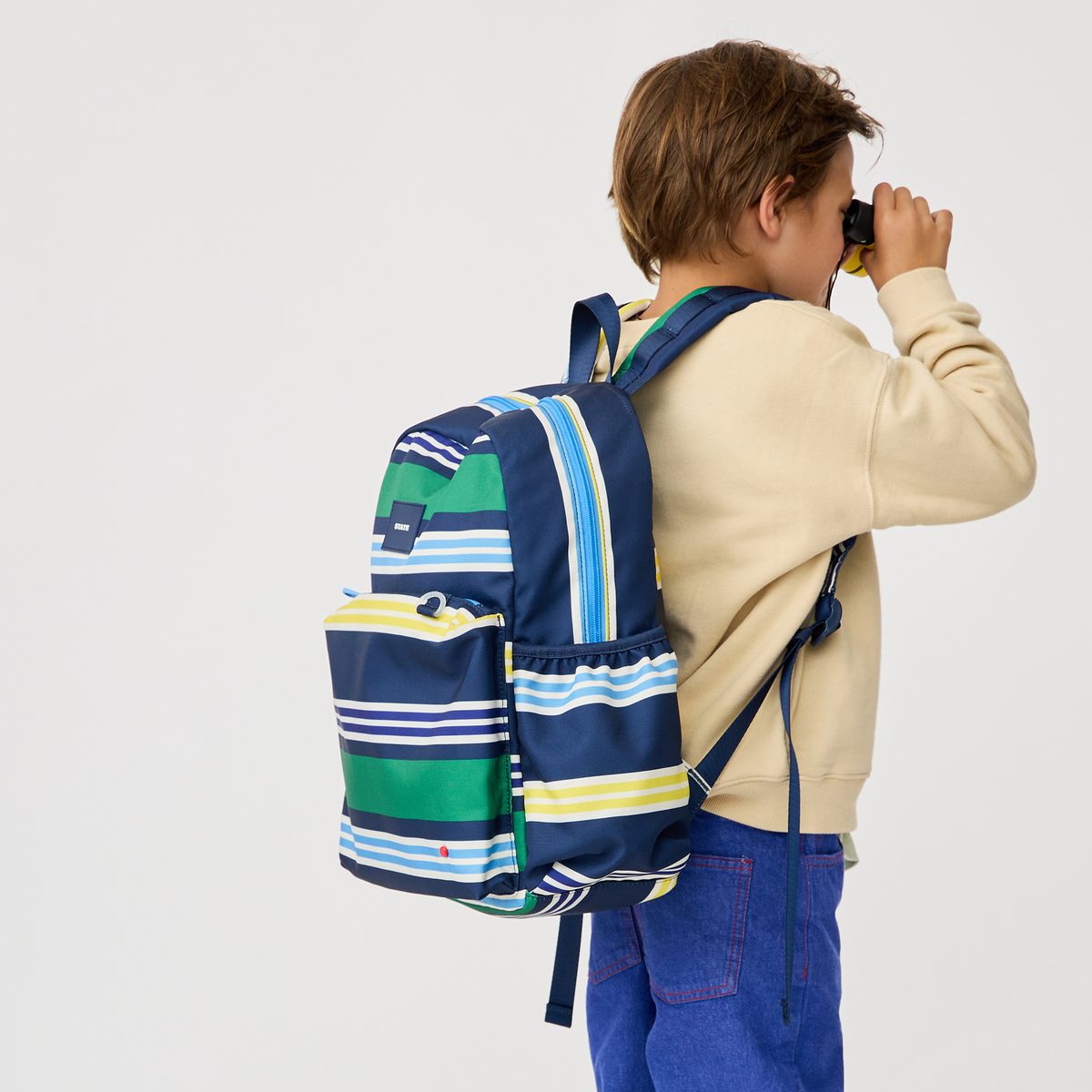 boy wearing STATE Bags Kane Backpack Polo Stripe