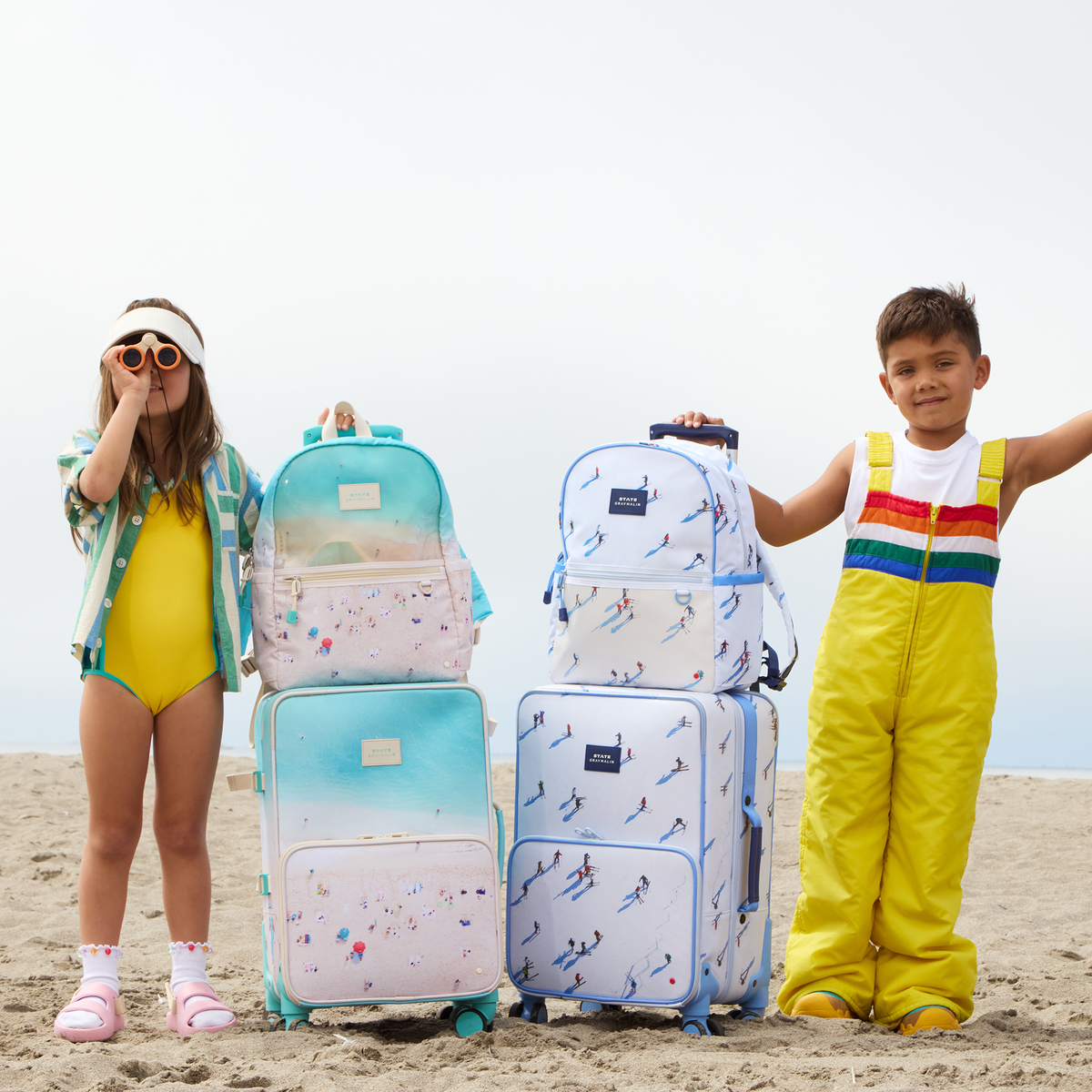 girl and boy standing with STATE x Gray Malin Logan Carry-On Suitcases