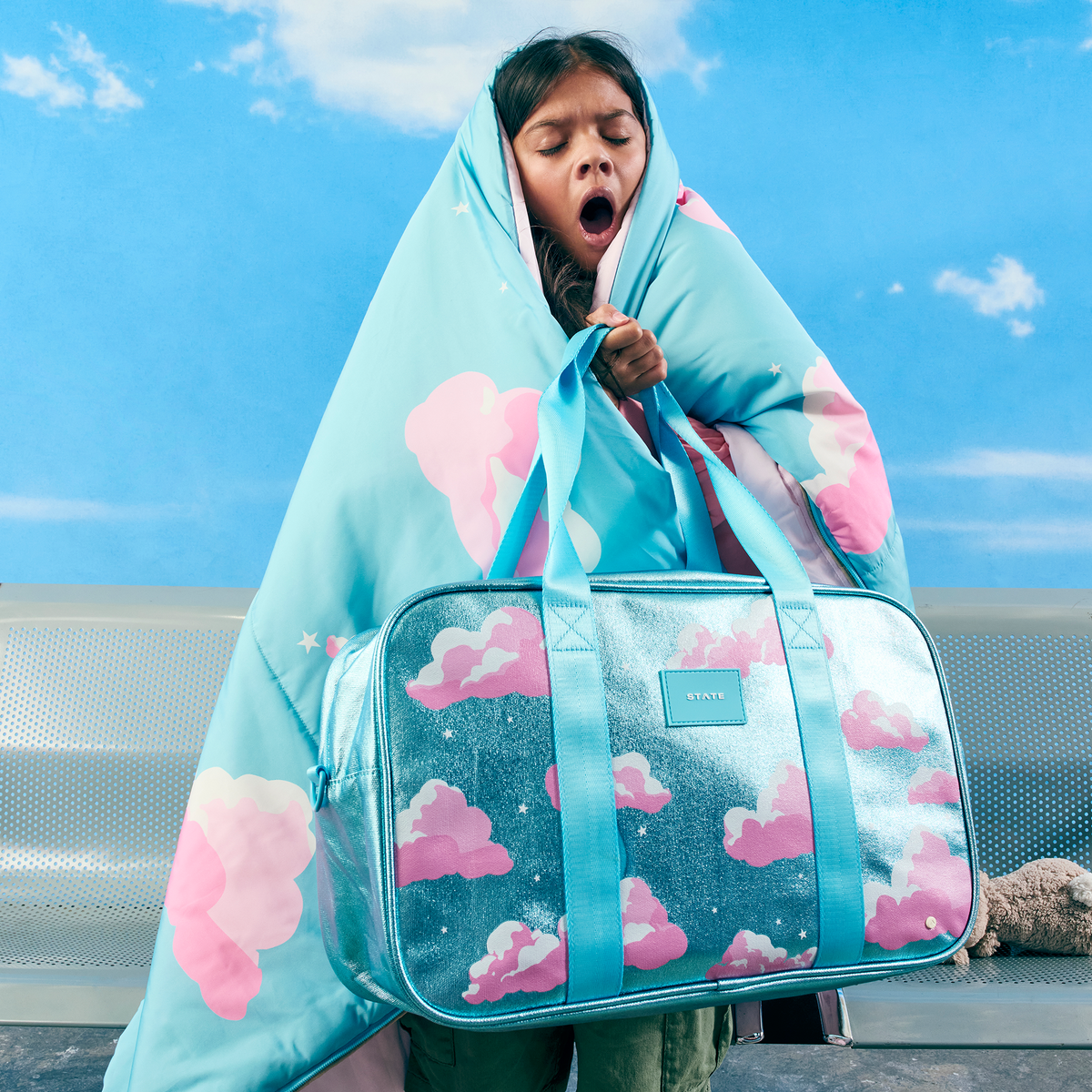 girl holding STATE Bags Rockaway Duffle Clouds