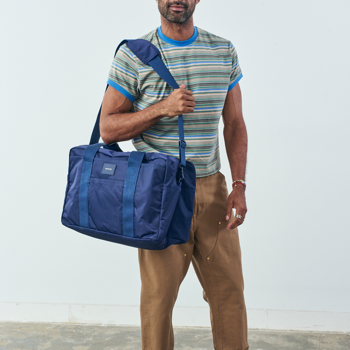 Man holding STATE Bags wellington weekender navy