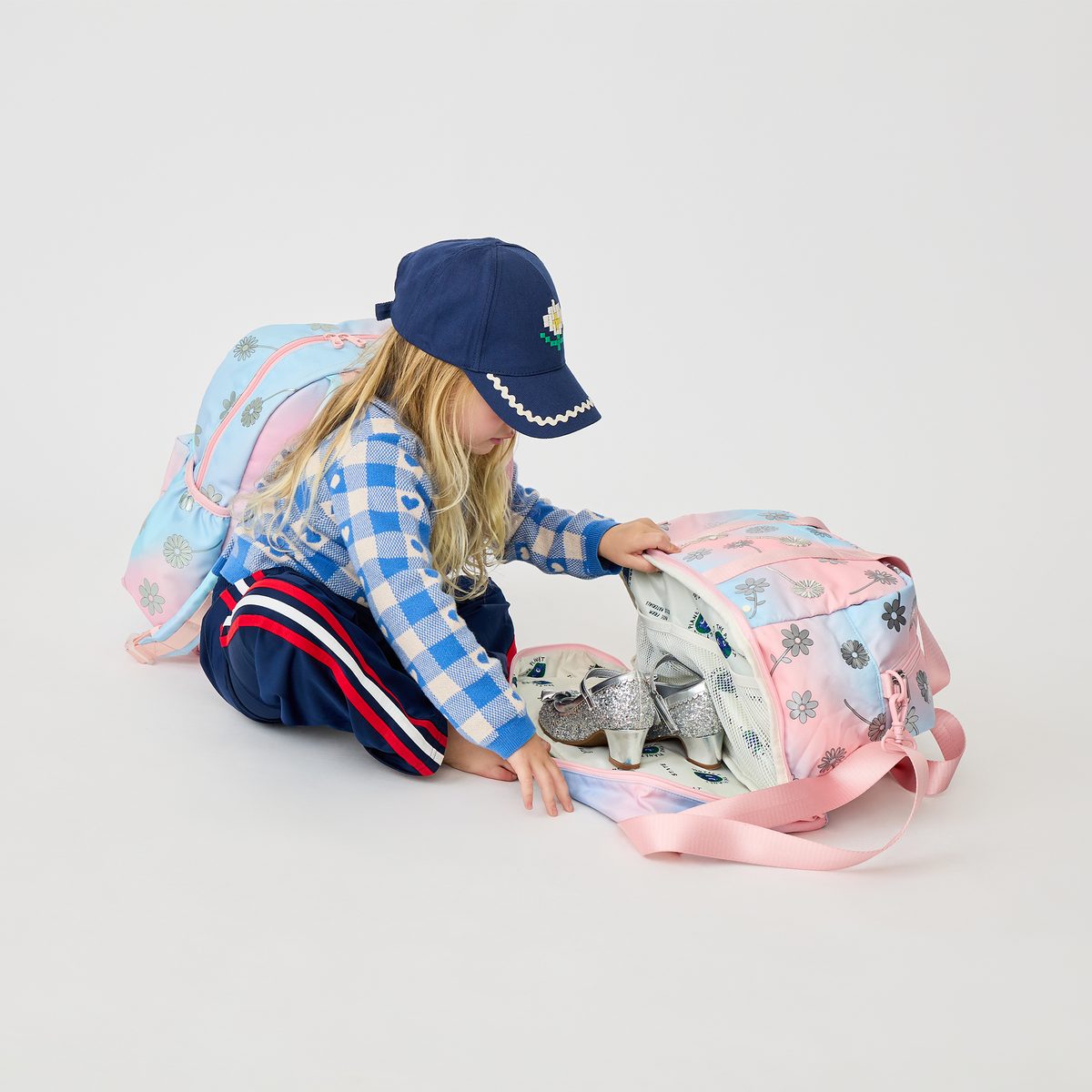 girl sitting with Wren Weekender and Kane Backpack Dreamy FLoral